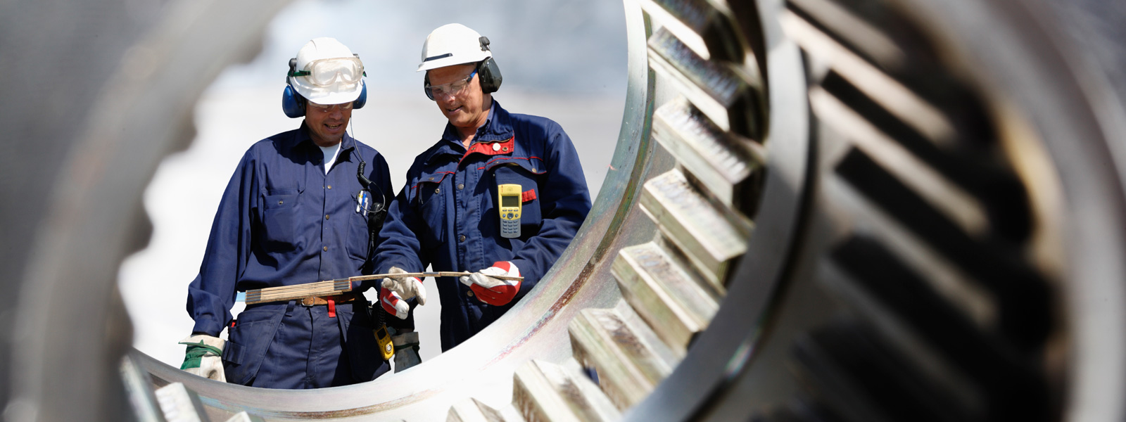 two workers behind a gear